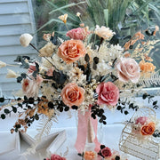 Full-size preserved bridal bouquet in coral blush and nude tones with roses, hydrangeas, eucalyptus, and soft dried florals, styled with flowing pink satin ribbon