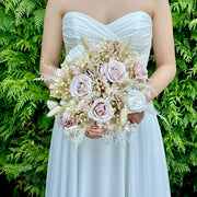 Bride holding a preserved nude blush bridal bouquet in a romantic wedding style