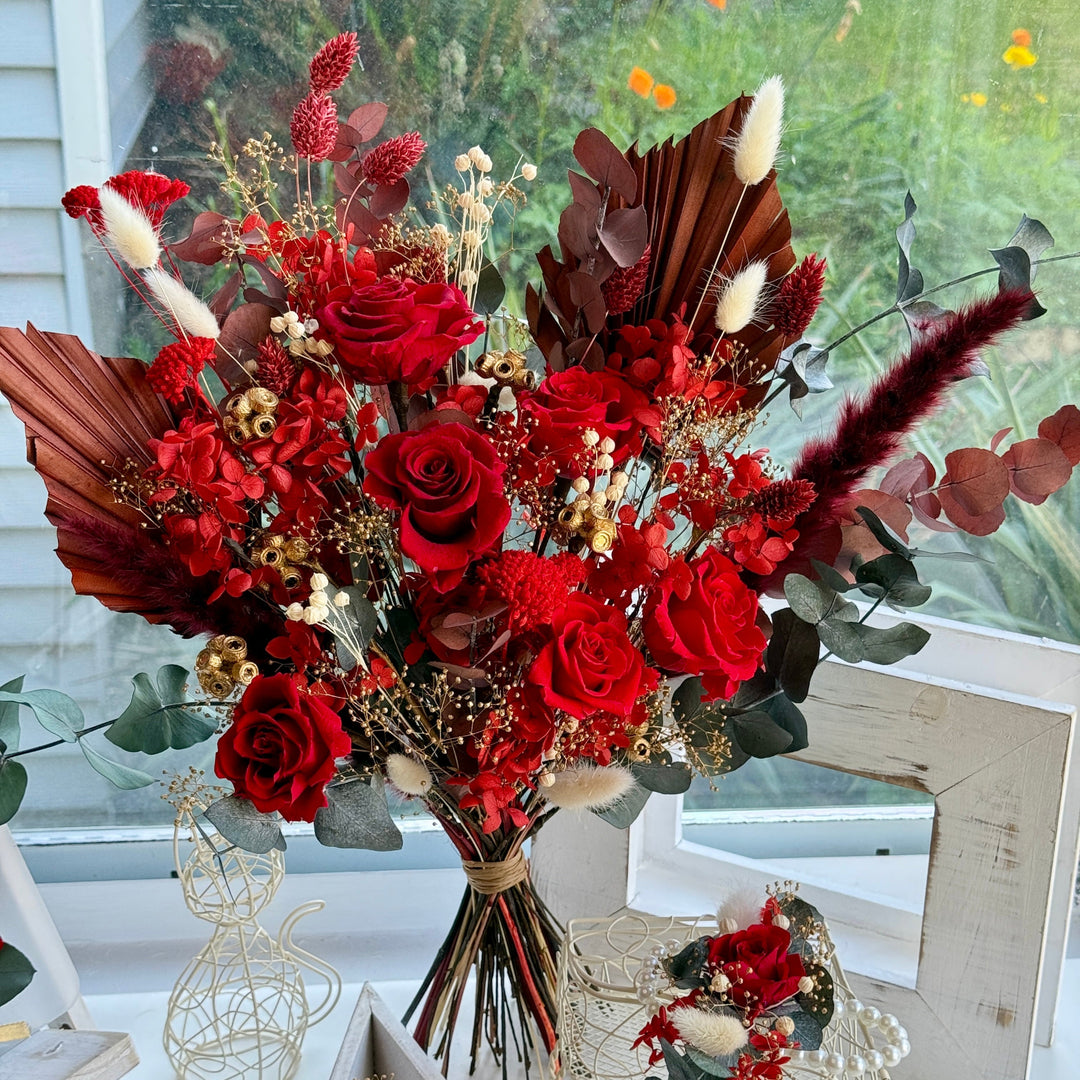 Luxury preserved red bridal bouquet with roses, palm leaves and gold accents