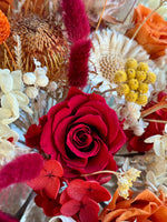 Load image into Gallery viewer, Close-up detail of crimson preserved roses, craspedia, and wild dried textures in a bohemian bridal bouquet