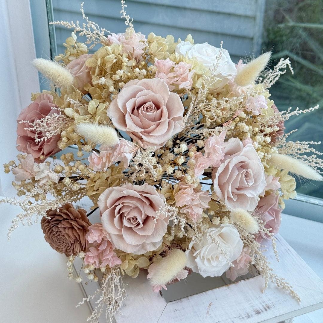 Close view of preserved bridal bouquet with blush roses and dried textures