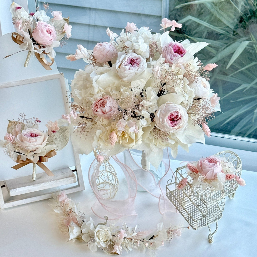 Blushing garden rose preserved bridal bouquet displayed with matching boutonniere and accessories