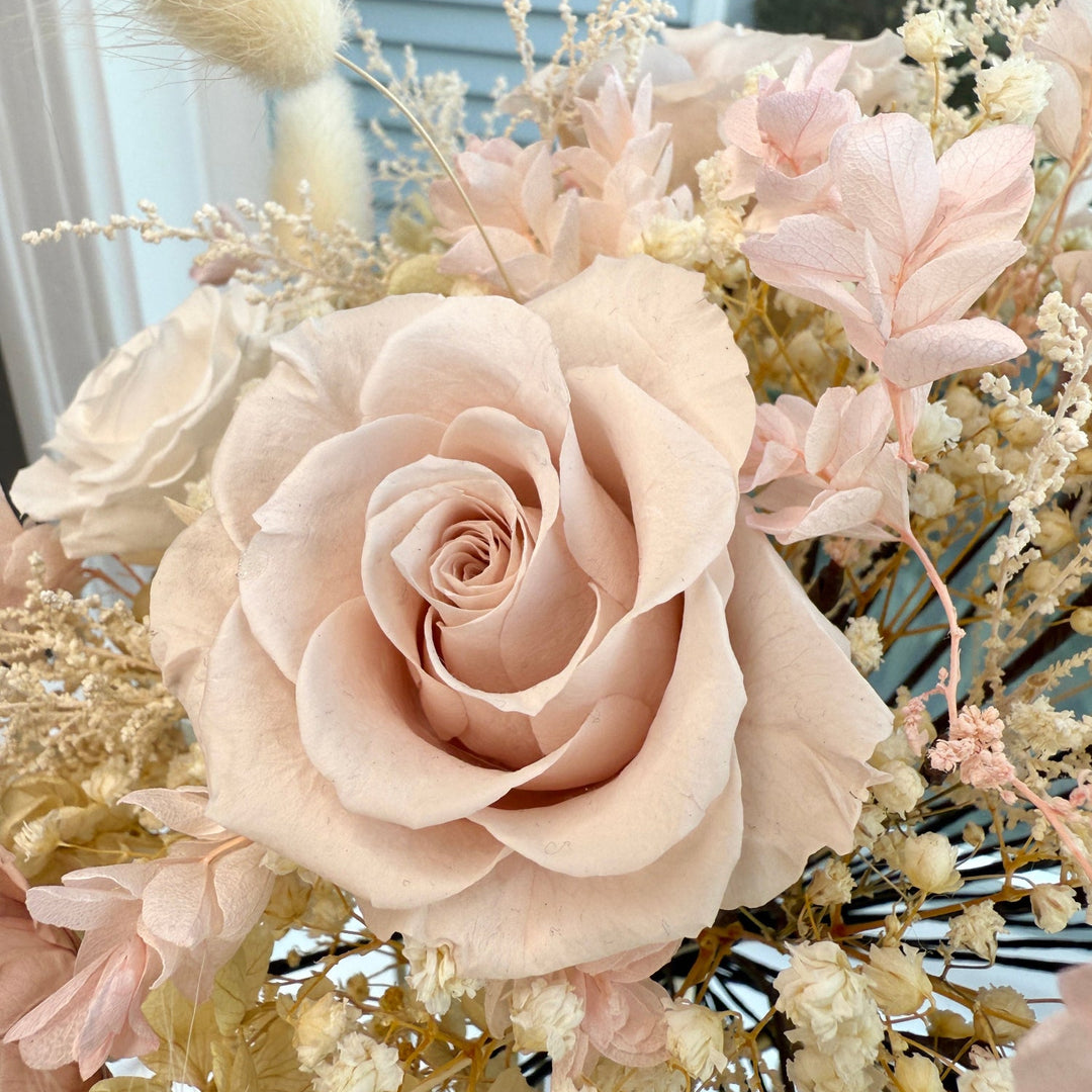 Close-up of preserved champagne and ivory flowers in bridal bouquet