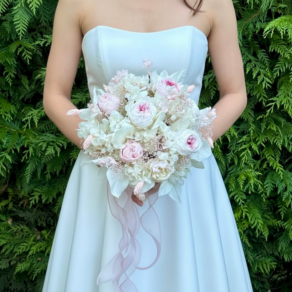 Bride holding a blushing garden rose preserved bridal bouquet in a white wedding dress